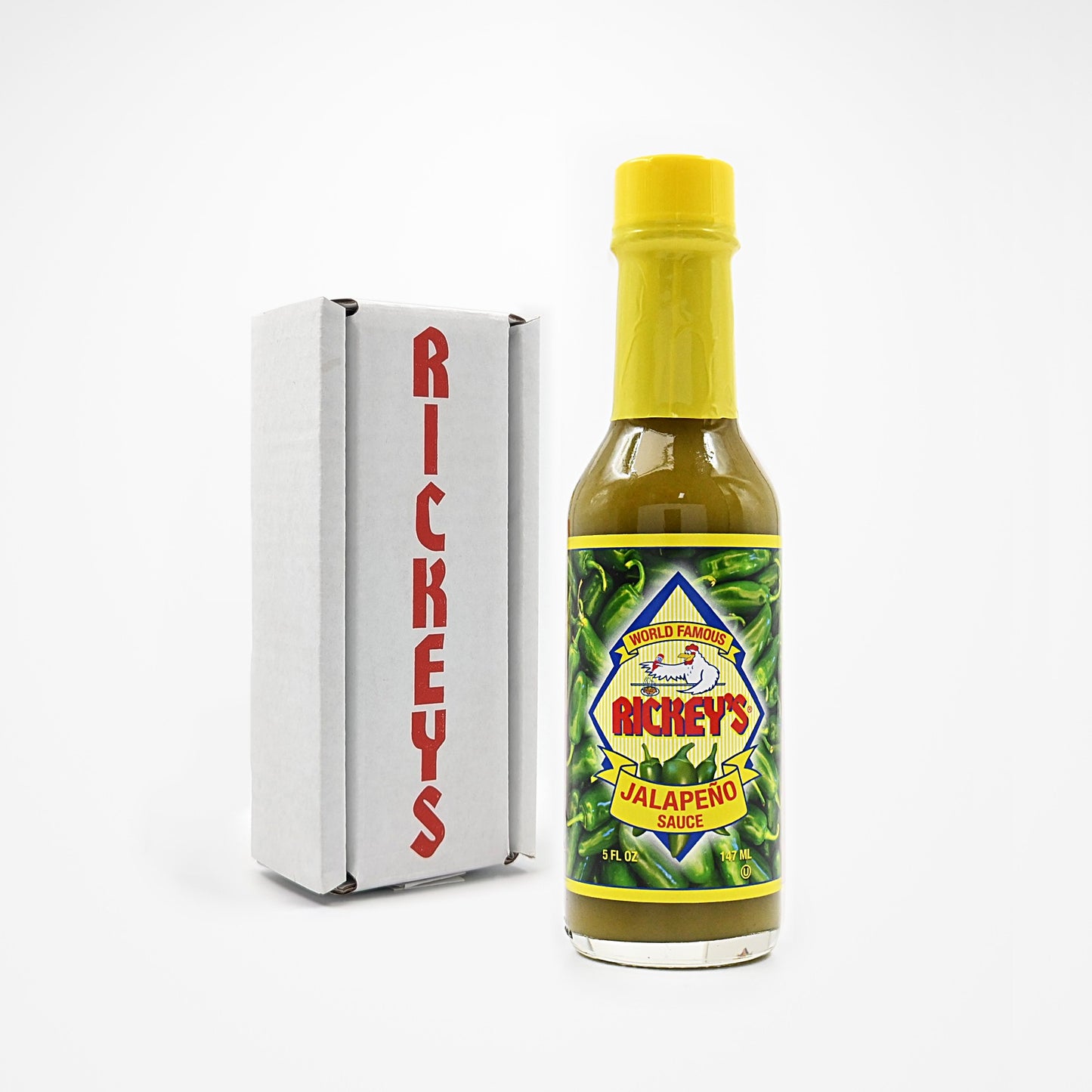 Bottle of Rickey's Jalapeño Sauce in front of a Rickey's box on a white background