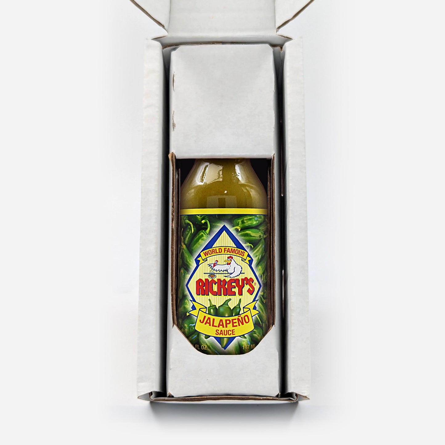 Bottle of Richey's Jalapeno Sauce inside a Rickey's box on a white background